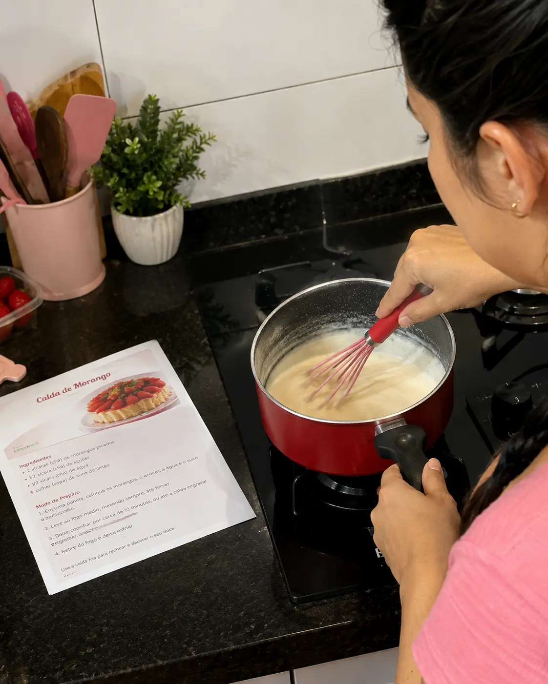 Preparando a calda no fogão com a receita impressa na bancada